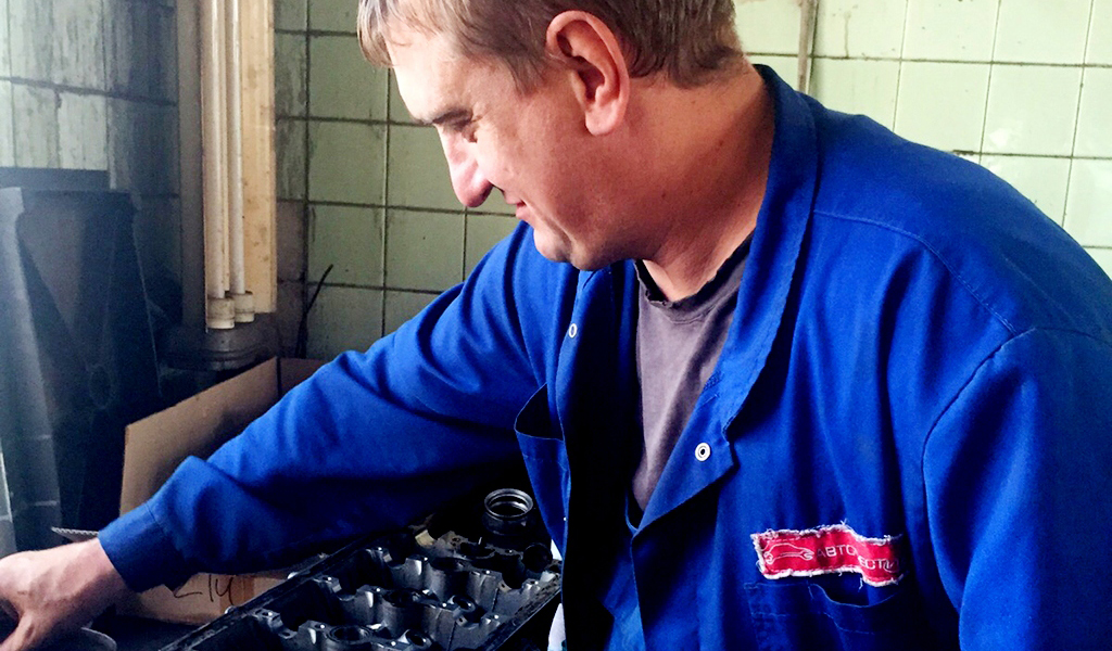 На фото мастер автосервиса разбирает ГРМ двигателя в рамках капитального ремонт
